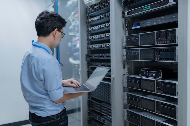 Computeringenieur stelt een netwerk op in de serverruimte System Maintenance Technician Mannelijke ingenieur werkt in de serverkamer in een modern datacentrum
