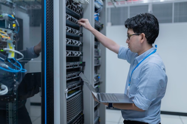Computeringenieur stelt een netwerk op in de serverruimte System Maintenance Technician Mannelijke ingenieur werkt in de serverkamer in een modern datacentrum