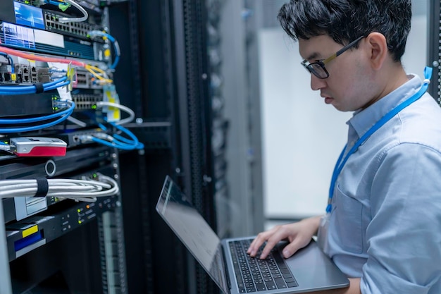 Computeringenieur stelt een netwerk op in de serverruimte System Maintenance Technician Mannelijke ingenieur werkt in de serverkamer in een modern datacentrum