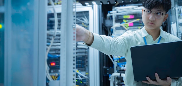 Computeringenieur stelt een netwerk op in de serverruimte System Maintenance Technician Mannelijke ingenieur werkt in de serverkamer in een modern datacentrum