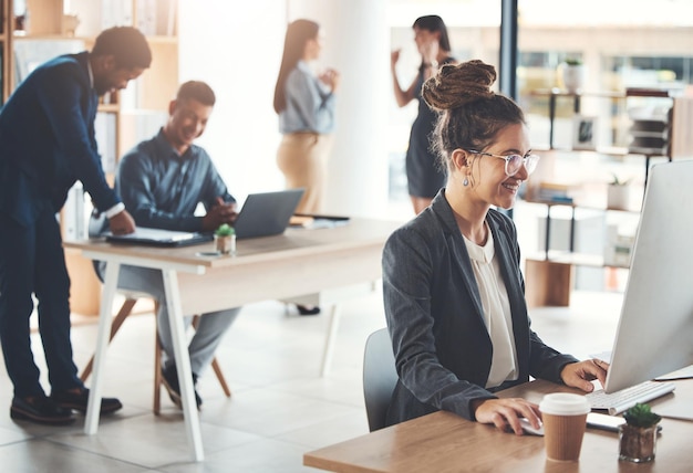 Foto computerkantoor en zakenvrouw typen e-mailrapport of werken aan project op de werkplek technologiebedrijf en gelukkige vrouwelijke werknemer op desktop-pc die onderzoek of planningsstrategie online schrijft