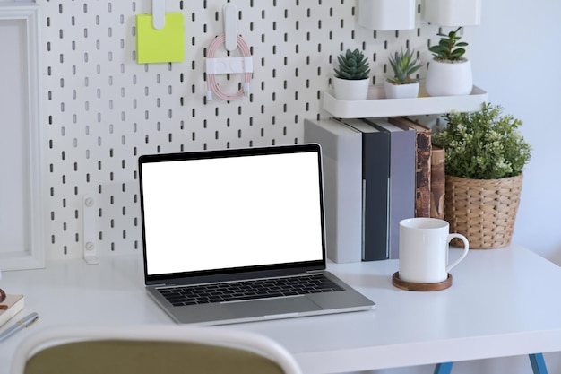 Computerlaptop met leeg scherm op wit bureau in thuiskantoor
