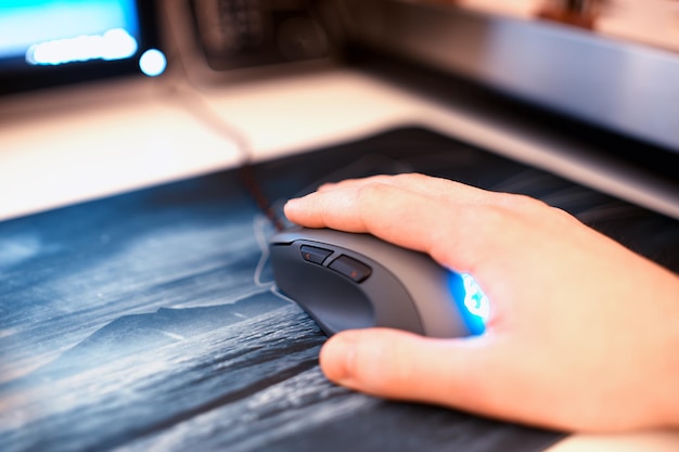 Foto computermuis met menselijke hand op mousepad bokeh achtergrond hd