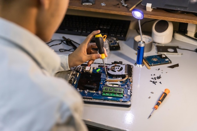 Computerreparatietechnicus die een laptop repareert