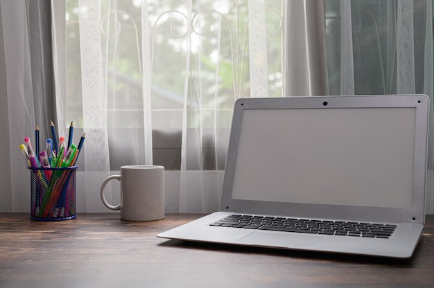 Computers, notebooks and water glasses are at the desk.