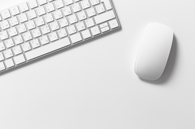 Computertoetsenbord en muis bovenop witte desktop