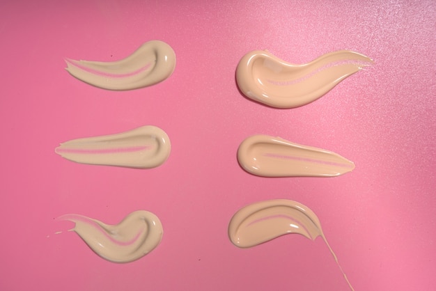 Concealer Foundation cream Swatches, assorted smears of different shades, on a bright pink modern background