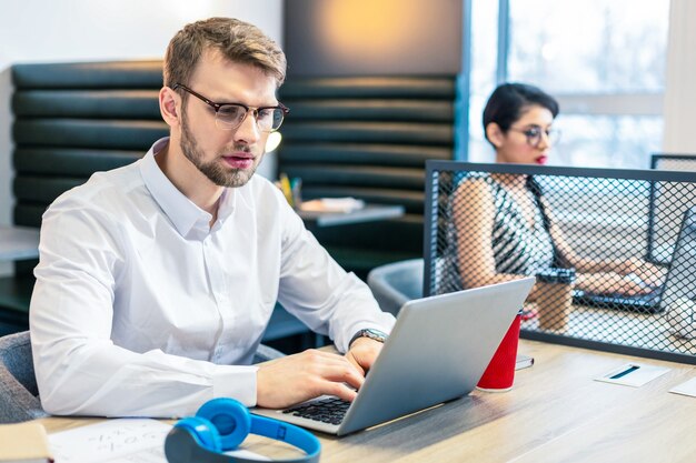 Concentrate on task. Handsome brunette male sitting at his workplace while checking his mailbox