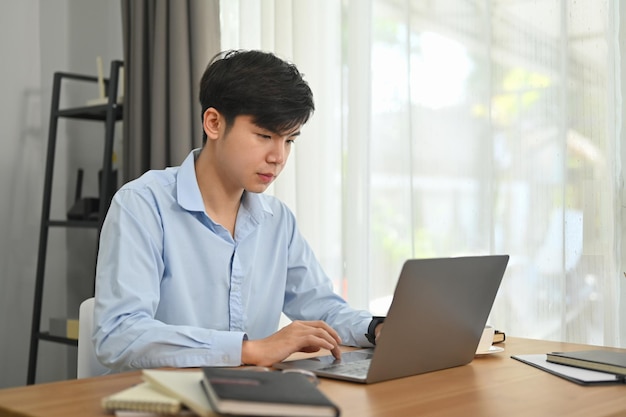 Concentrated asian male working on commercial and marketing project at modern home office