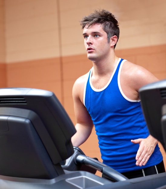 Concentrated athletic man training on a running machine