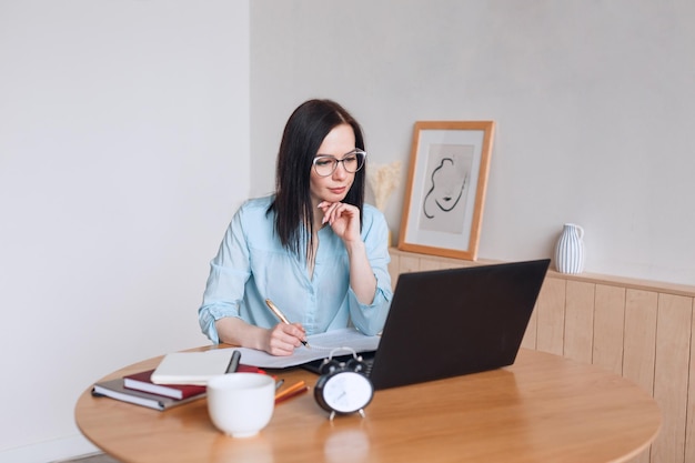 Concentrated beautiful businesswoman working on laptop in modern office