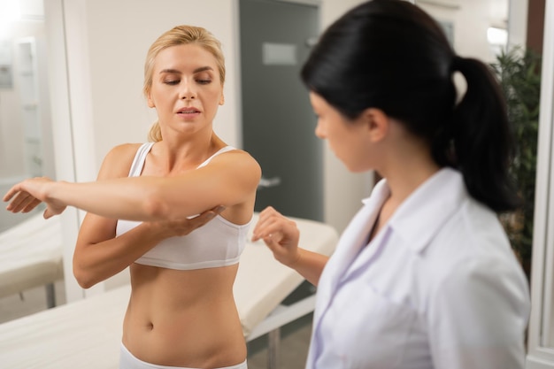 Concentrated beauty doctor seeing her worried patient