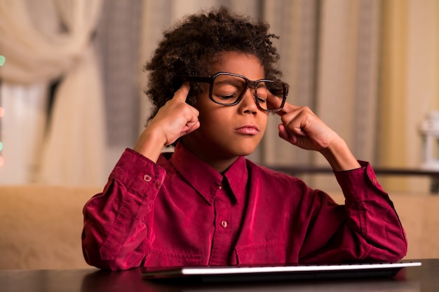 Concentrated black boy at keyboard.