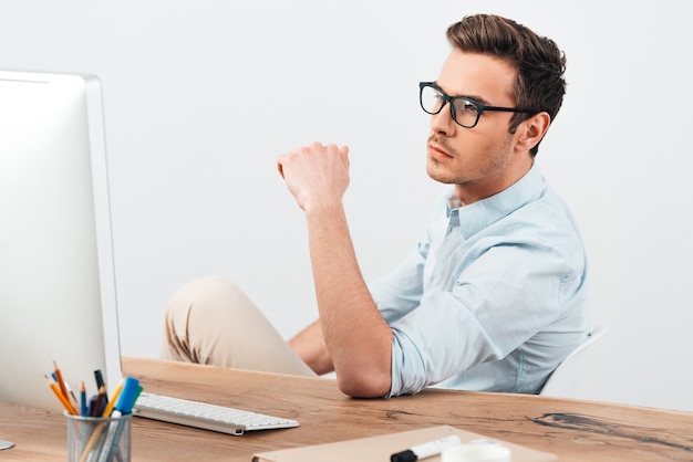 Concentrated businessman. Pensive young handsome man looking at his computer screen 