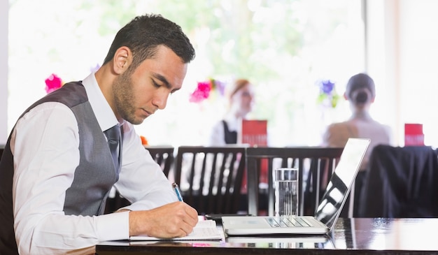 Concentrated businessman writing something