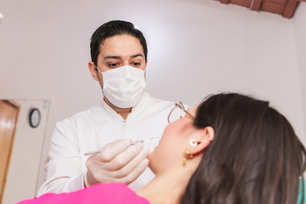 Photo concentrated dentist working on his patients teeth in the dental office