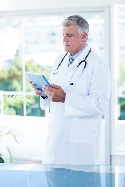 Photo concentrated doctor holding tablet