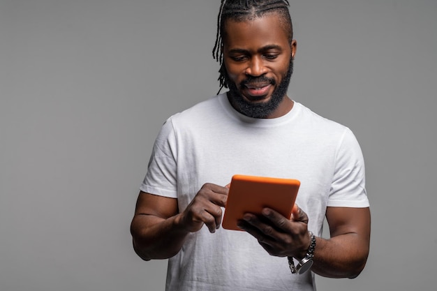 Concentrated guy surfing the net on his gadget