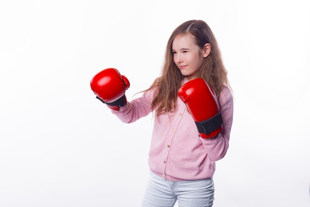 Concentrated little girl is wearing some red gloves for box.