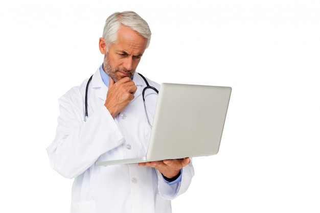 Concentrated male doctor using laptop