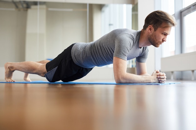 Concentrated man doing plank pose