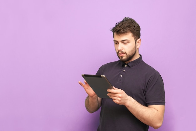 Concentrated man uses the internet on a tablet