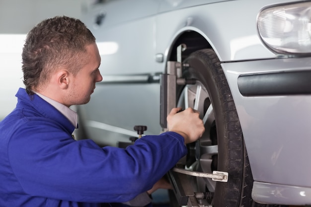 Concentrated mechanic repairing a car wheel