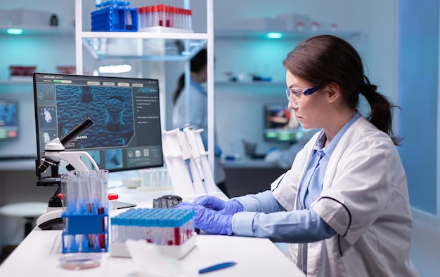 Concentrated professional woman scientist in laboratory with modern equipment