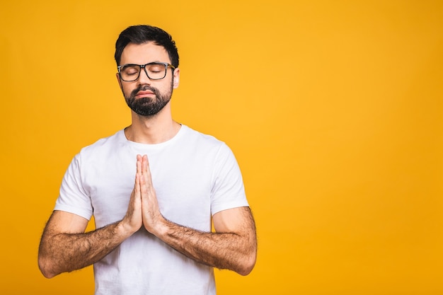 Concentrated relaxed person, standing with closed eyes, having relaxation while meditating, trying to find balance and harmony.