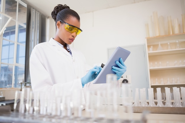 Concentrated scientist working with tablet 