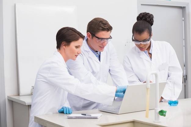 Concentrated scientists working together with laptop