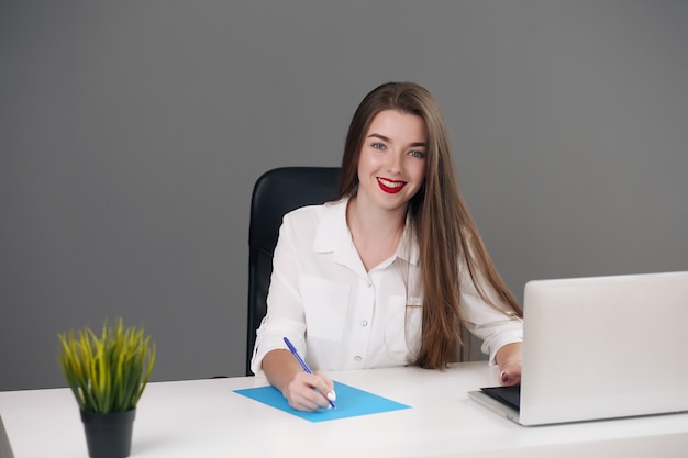 Concentrated smart young businesswoman using her computer in the office.