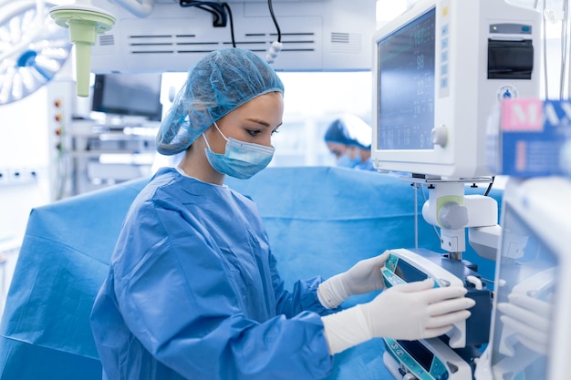 Сконцентрированная хирургическая бригада, работающая с пациентом в операционной Хорошо обученный анестезиолог с многолетним опытом работы со сложными аппаратами следует за пациентом на протяжении всей операции