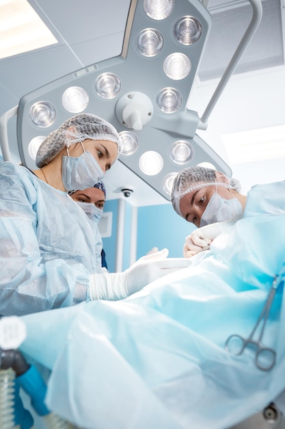 Concentrated Surgical team operating a patient in an operation theater Welltrained anesthesiologist with years of training with complex machines follows the patient throughout the surgery