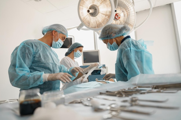 Фото Сконцентрированная хирургическая бригада, работающая с пациентом в операционной