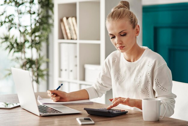 Concentrated woman budgeting at office