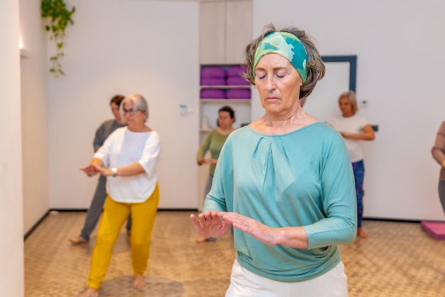 Concentrated woman exercising during qi gong class