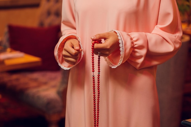 Concentrated woman praying wearing rosary beads Namaste Close up hands