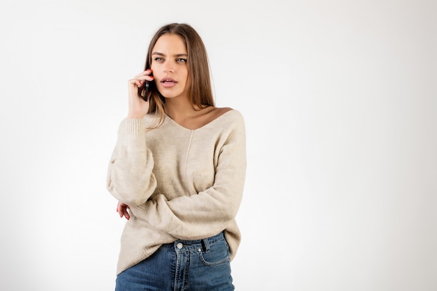 白で分離された電話で話している女性を集中してください。