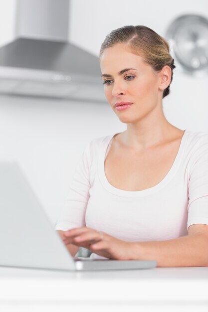 Concentrated woman typing on laptop