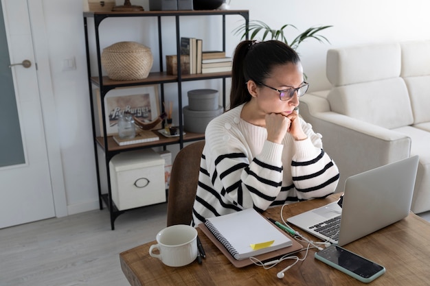 Concentrated woman works from home with her laptop