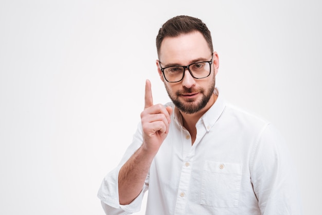 Concentrated young bearded man pointing