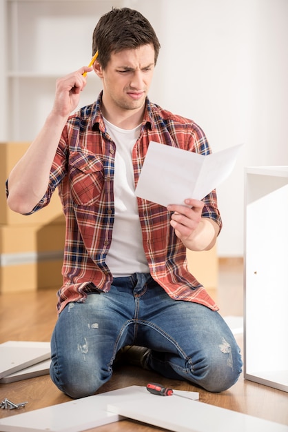 Concentrated young man reading the instructions.