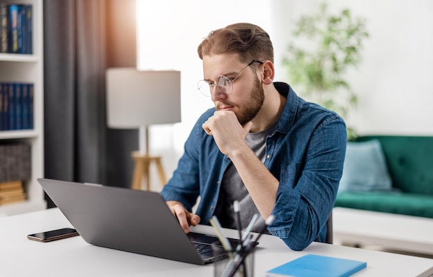 Photo concentrated young man sitting at table