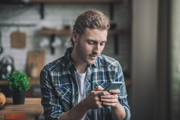 Concentrated young man texting on smartphone