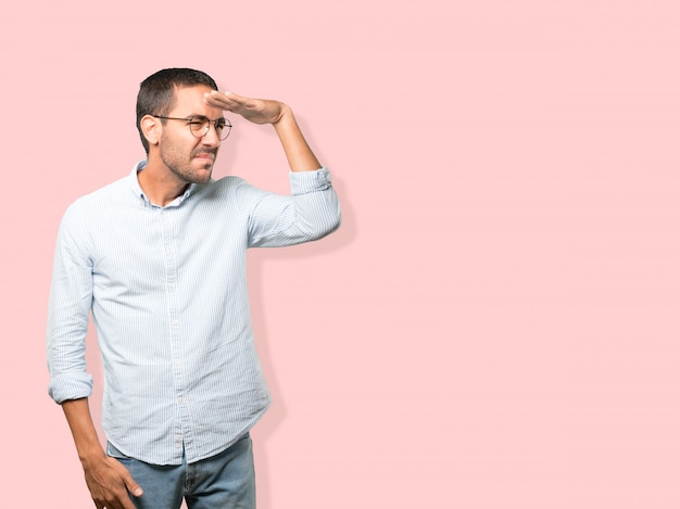 Photo concentrated young man with a gesture of looking away