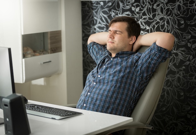 Concentrated young man working on computer at home office