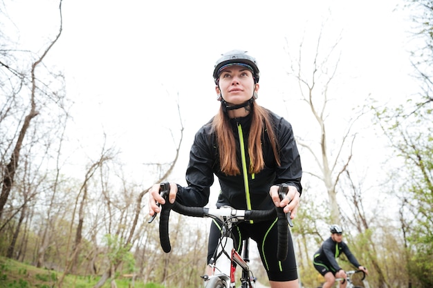 公園で自転車に乗る集中した若い女性