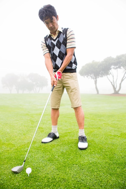 Concentrating golfer lining up his shot