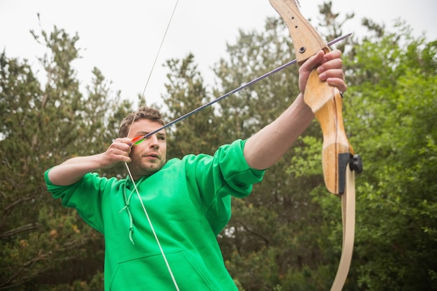 Concentrating man practicing archery